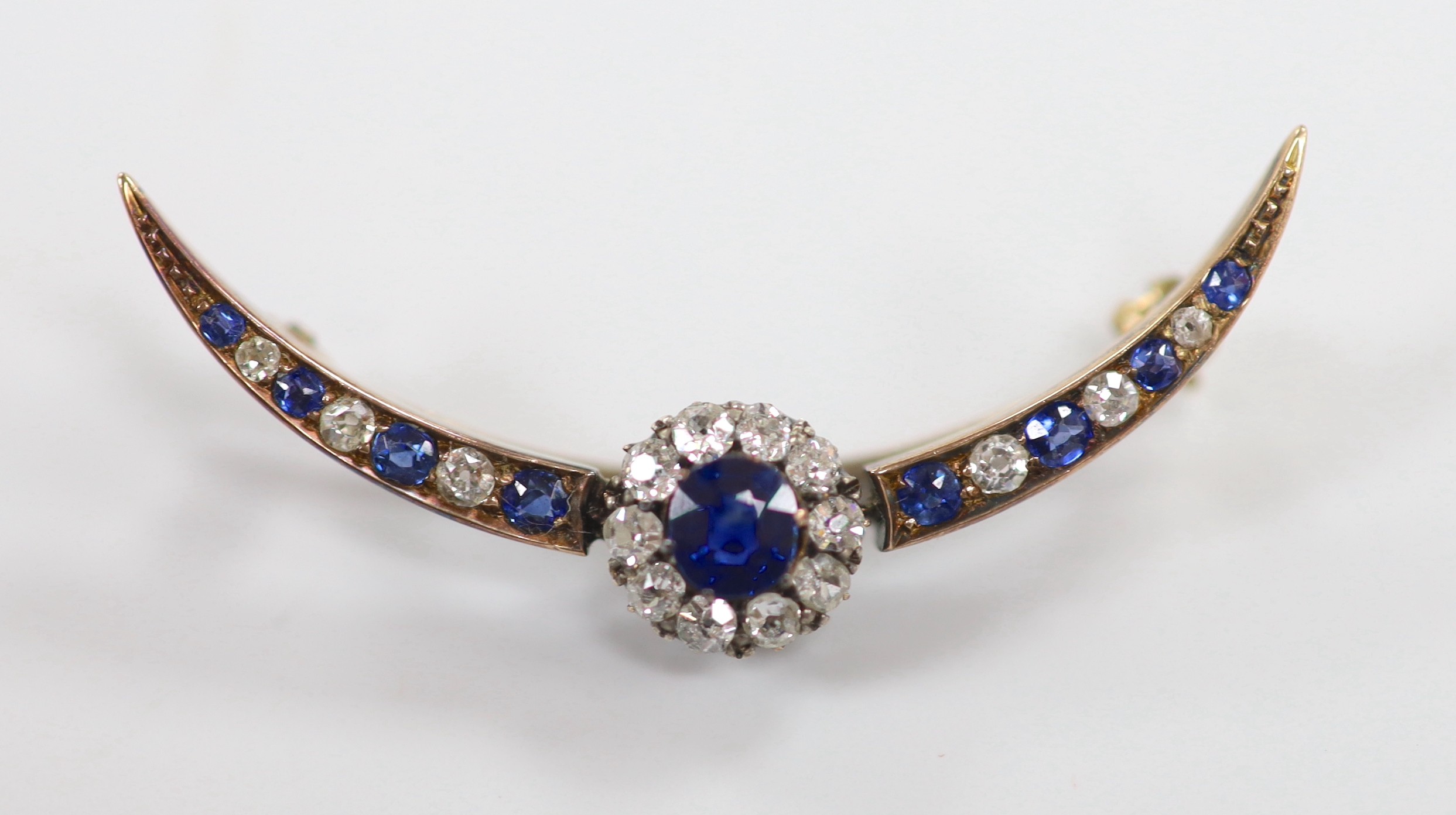 A Victorian yellow metal, sapphire and diamond cluster set crescent brooch, 42mm, gross weight 3.9 grams.